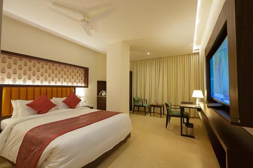 a hotel room with a large bed and a flat screen tv at Grand Continent Secunderabad A Sarovar Portico Affiliate Hotel in Secunderabad