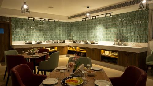 a restaurant with tables and chairs and a kitchen at Grand Continent Secunderabad A Sarovar Portico Affiliate Hotel in Secunderabad