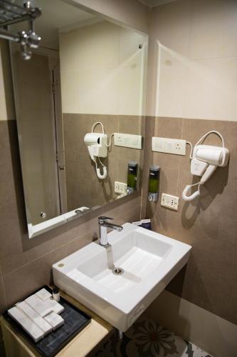 a bathroom with a sink and a mirror at Grand Continent Secunderabad A Sarovar Portico Affiliate Hotel in Secunderabad