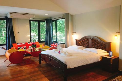 een slaapkamer met een bed en een tafel en stoelen bij Busaya Resort & Cuisine in Nakhon Pathom