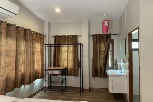 een badkamer met een douchegordijn en een wastafel bij Busaya Resort & Cuisine in Nakhon Pathom