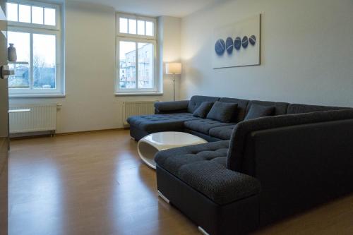 salon z kanapą i stołem w obiekcie Studiowohnungen Am Neuberinhaus F&G Apartments w mieście Reichenbach im Vogtland