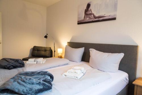 sypialnia z 2 łóżkami i ręcznikami w obiekcie Studiowohnungen Am Neuberinhaus F&G Apartments w mieście Reichenbach im Vogtland