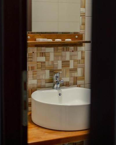 a white sink in a bathroom with a mirror at Hotel Kyani Akti in Xylokastron