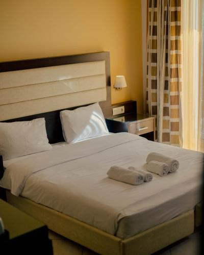 a bedroom with a bed with two towels on it at Hotel Kyani Akti in Xylokastron