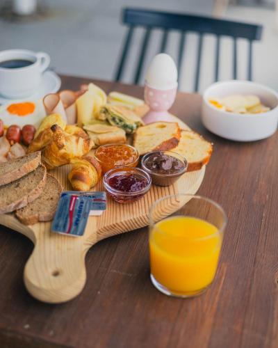 a wooden table with a plate of food and a glass of orange juice at Hotel Kyani Akti in Xylokastron