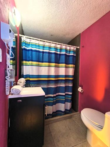 a bathroom with a shower curtain and a toilet at El Refugio de San Matías in Guanajuato