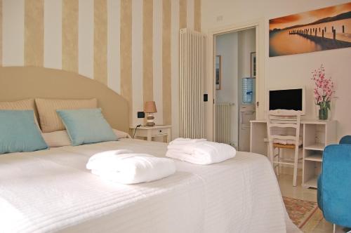 a bedroom with a white bed with two pillows on it at B&B Iulia Augusta in Albenga