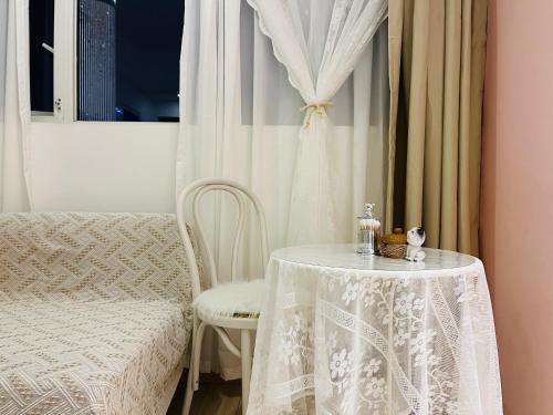 重慶市にある重庆山川的民宿四店の白いカーテン付きの椅子とテーブル