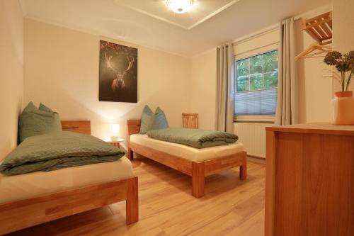 um quarto com 2 camas e uma janela em Forsthaus Heidelberg Prignitz 