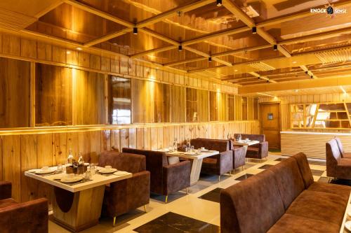 a restaurant with wooden walls and tables and chairs at The Ecstasy Hotel in Lucknow