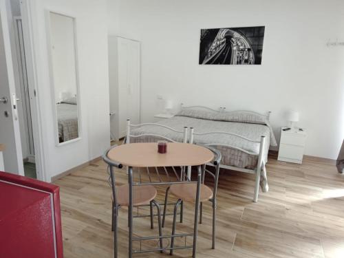 sypialnia z łóżkiem, stołem i krzesłami w obiekcie Paolessi House w mieście Rieti