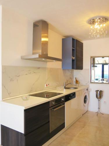 a kitchen with a sink and a dishwasher at Seafront apartment Terrace, lounger & Panoramic ocean views in Mellieħa