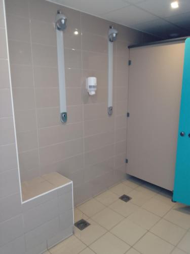 une salle de bain avec une douche avec une porte vitrée dans l'établissement Appartement dans residence de tourisme, à Besse-et-Saint-Anastaise