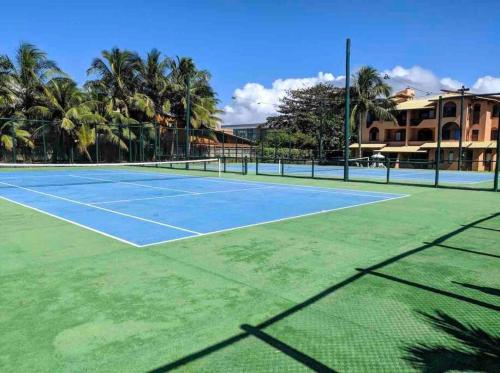 a tennis court with palm trees in the background at Seu cantinho no paraíso de Guarajuba - Bahia in Guarajuba
