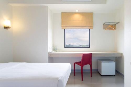 1 dormitorio con cama, escritorio y silla roja en Baan MangMee Resort Udonthani en Udon Thani