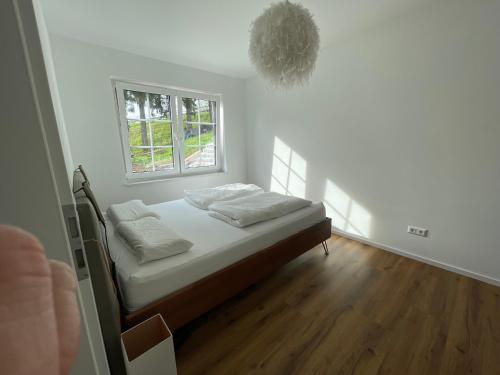 a bedroom with a bed with white sheets and a window at Gemütliche Wohnung im Herzen von Schwäbisch Gmünd in Schwäbisch Gmünd