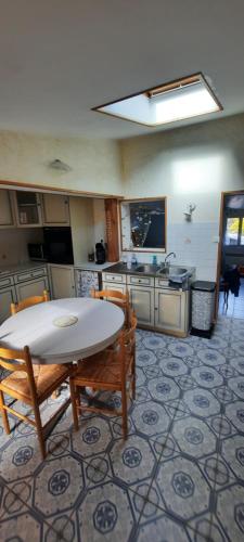 une cuisine avec une table et des chaises dans une pièce dans l'établissement location ault, à Ault