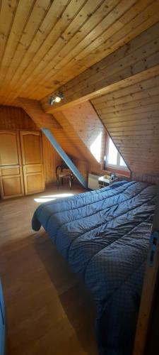 un lit dans une chambre avec un plafond en bois dans l'établissement location ault, à Ault