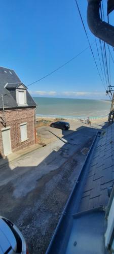 Elle offre une vue sur la plage, le bâtiment et l'océan. dans l'établissement location ault, à Ault