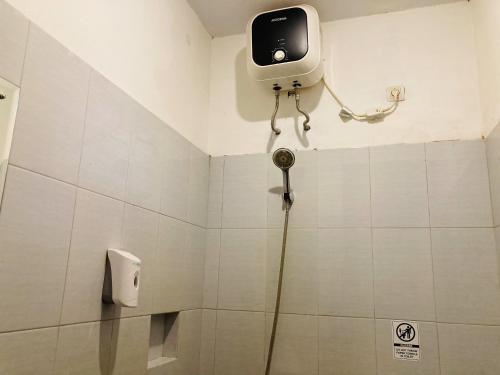a bathroom with a shower with a camera on the wall at Hotel Candra Kirana Syariah Prawirotaman Mitra RedDoorz in Yogyakarta