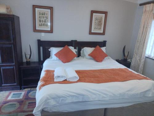 a bedroom with a large bed with two towels on it at Lapalosa Lodge in Centurion