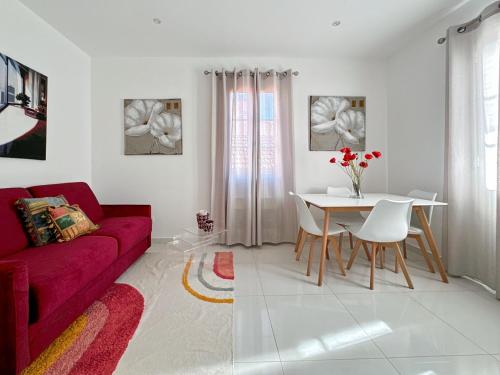 un salon avec un canapé rouge et une table dans l'établissement Tivoli 3 - Renovated 2 bedrooms appartment, Nice terrace, Monaco Border, 5mn from Casino Monte Carlo, à Beausoleil