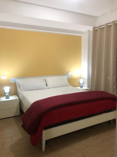 a bedroom with a large bed with a red blanket at Thalassa Suite & Spa in Reggio Calabria
