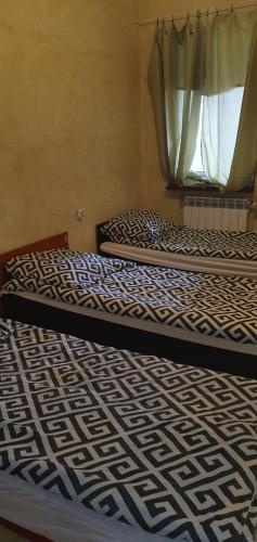 2 camas en una habitación con ventana en Pokój typu studio dla pracownikow z kuchnią i łazienka, en Tomaszów Mazowiecki