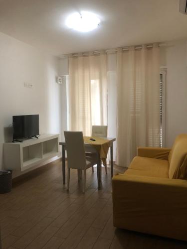 a living room with a couch and a table and a tv at Thalassa Suite & Spa in Reggio Calabria