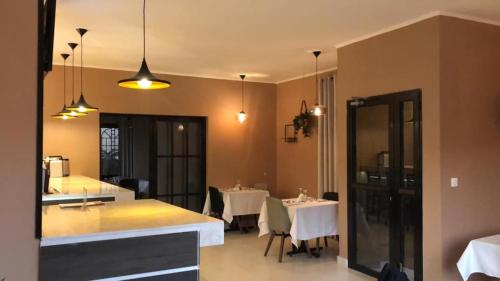 a dining room with tables and chairs and lights at Hotel la chaumiere in Bamako