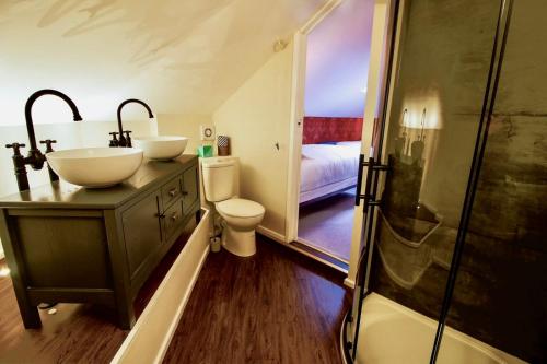 ein Badezimmer mit zwei Waschbecken, einem WC und einer Dusche in der Unterkunft Plas Dolguog in Machynlleth