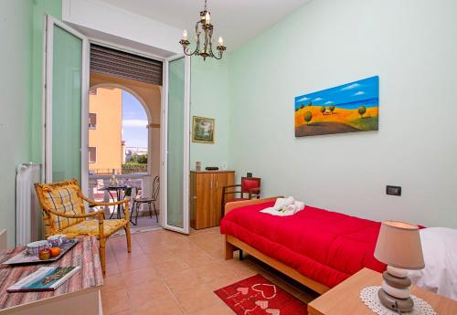 1 dormitorio con cama roja y mesa en Villa Mimosa - Appartamento 1 - Happy Rentals, en Desenzano del Garda