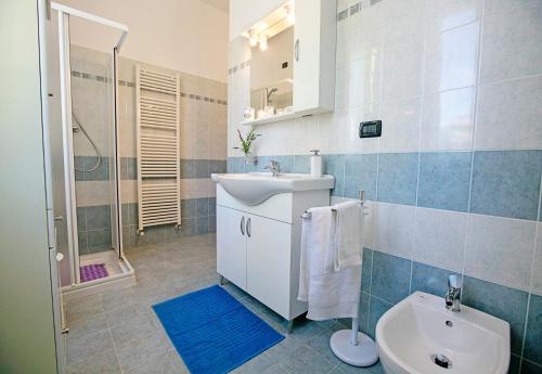 e bagno con lavandino, servizi igienici e doccia. di Villa Mimosa - Appartamento 1 - Happy Rentals a Desenzano del Garda