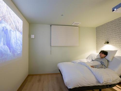 a man sitting on a bed in a room at Rakuten STAY VILLA Nasu Villa Capacity of 10 persons with Kitchen Tools Type No pet allowed in Nasu-yumoto