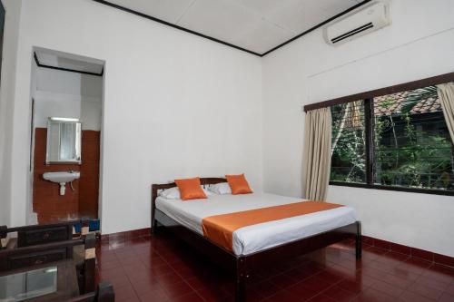 a bedroom with a bed and a window at Oryza Hotel Malioboro in Sentool
