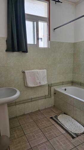 een badkamer met een bad en een wastafel bij Résidence Mareva in Antananarivo
