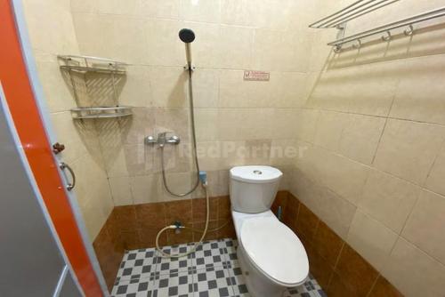 uma pequena casa de banho com WC e chuveiro em Hotel California Mitra RedDoorz em Pembunuh