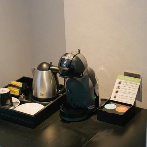 a coffee maker and a tea kettle on a table at Awann Sewu Boutique Hotel and Suite Semarang in Semarang