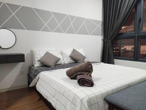 een slaapkamer met een bed met een handdoek erop bij M Vertica 3BR KL Cheras with Netflix in Kuala Lumpur