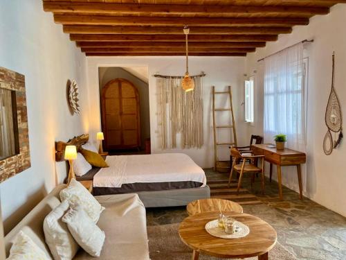 a bedroom with a bed and a couch and a table at Sunset Villa Iza in Agios Ioannis Mykonos