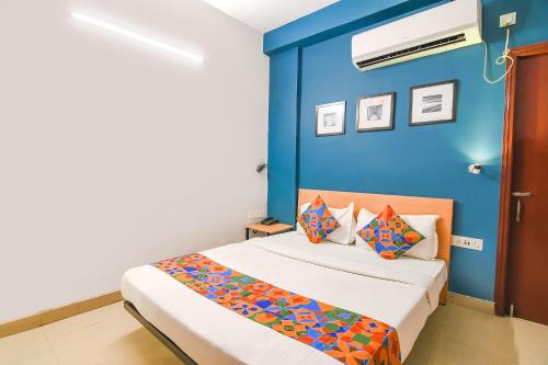 a bedroom with a bed with a blue wall at FabExpress P3 in Ballygunge