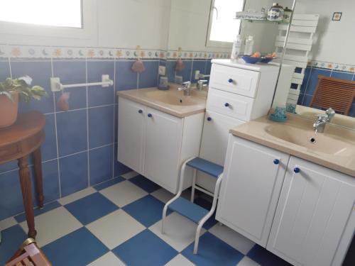 Baño azul y blanco con 2 lavabos y espejo en La P'tite Etape, en Talmont