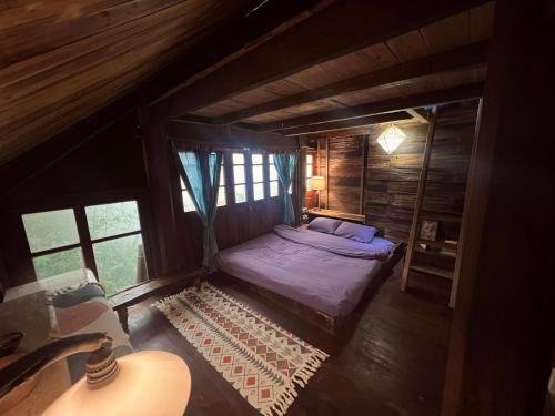 małe łóżko w drewnianym pokoju z oknami w obiekcie Chapi Dreamy Home w mieście Sa Pa