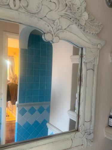 La salle de bains est pourvue d'un miroir et de carrelage bleu. dans l'établissement Sirem Boutique Apartament, à Assemini