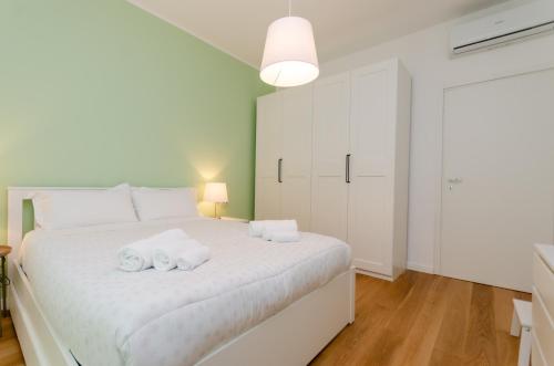 a bedroom with a large white bed with towels on it at Vivimi Home Fiordalisi Stile & Comfort Vicino Metro in Milan