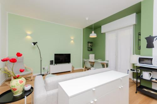 a living room with green walls and a white couch at Vivimi Home Fiordalisi Stile & Comfort Vicino Metro in Milan
