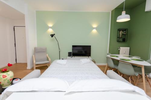 a room with three beds and a table and chairs at Vivimi Home Fiordalisi Stile & Comfort Vicino Metro in Milan