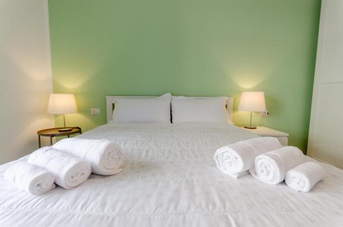 a bedroom with a white bed with towels on it at Delizioso Appartamento - A/C, Netflix e Balcone in Milan