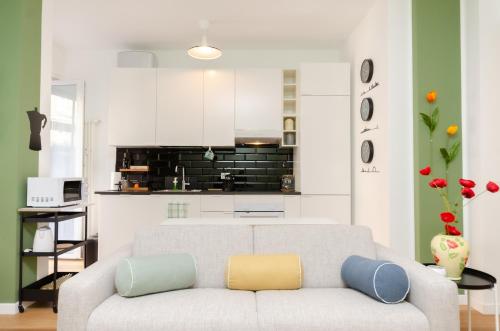 a living room with a couch and a kitchen at Delizioso Appartamento - A/C, Netflix e Balcone in Milan